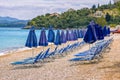 View of empty beach Ã¢â¬â blue deck chairs and umbrellas near sea water Royalty Free Stock Photo